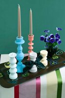 Turned wooden candlesticks in pastel shades and pansies on a vintage tray