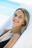 A blonde woman relaxing in a sunlounger by the pool