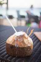 Aufgeschlagene Kokosnuss mit Strohhalm