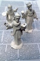Christmas crib figurines dipped in plaster drying on newspaper