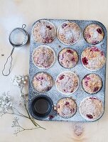 Cream cheese muffins with red berries in a cake tin