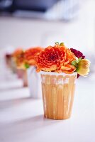 Apricot dahlias in row of vases