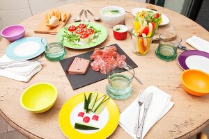 A table set for evening tea with vegetable sticks, 'toadstools' and assorted cold cuts