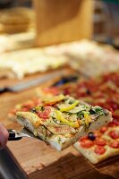 A slice of pizza on a pizza shovel in a trendy eatery in Hamburg, Germany