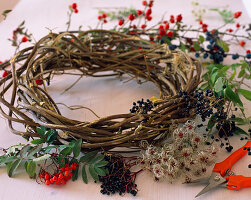 Herbstkranz binden; Zutaten: Clematisranken, Hagebutten, Schlehen