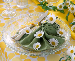 Serviette auf Glasteller mit Leucanthemum (Margerite)