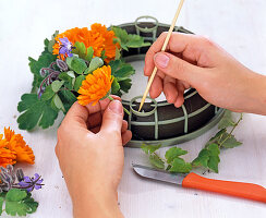 Sticking on calendula wreath