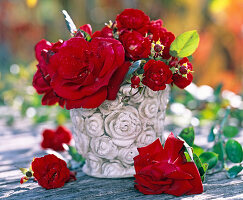 Strauß aus Rosa (Rosen), rot in Steinvase mit Rosenornamentik