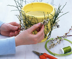 Ranunculus-daffodil bouquet in a planter decorated with twigs (3/5)