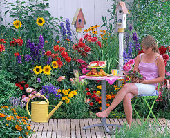 Sitzplatz am bunten Sommerbeet: Dahlia (Dahlien), Helianthus (Sonnenblumen)