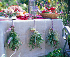 Herbs as table decoration with bouquets of salvia, rosmarinus