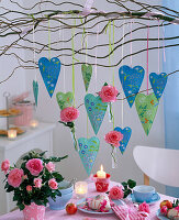 Branch of Salix (corkscrew willow) with hearts above a laid table