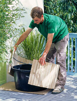 Cover the water plant tub with wood