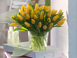 Tulipa (tulip) in glass vase on wooden tray