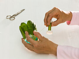 Dahlia flowers in glasses with rhododendron leaves (4/6)