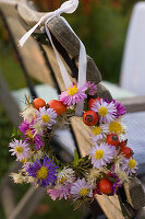 Set table in front of autumn bed: wreath of Aster (autumn asters), Rosa