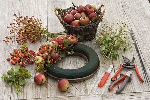 Putting a wreath of apples, rose hips and clematis (1/2)