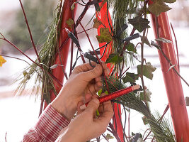 Adventskalender und Weihnachtsbaum mit roten Stangen (10/12)