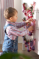 Advent calendar made of little socks hung on a chest of drawers