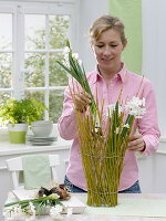 Fence of dogwood branches around glass vase (2/3)