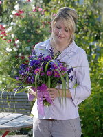 Young woman with bouquet of Callistephus (summer asters), Erigeron