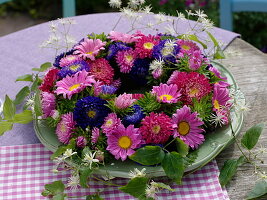 Plate wreath of summer asters and wild forest vine