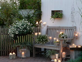 Weiße Abendterrasse mit Windlichtern und Kerzen