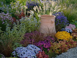 Buntes Herbstbeet mit Amphore und Astern