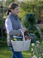 Young woman carrying wicker basket with flower bulbs and bulb setter