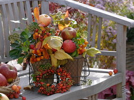 Autumn arrangement with apples, ornamental apples, rose hips and ivy