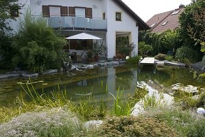 Schwimmteich mit Holzsteg an der Terrasse