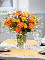 Yellow-orange spring bouquet of Ranunculus (Ranunculus), Rosa 'Circus'.