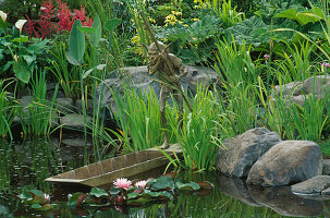 Water Feature: Water Garden with SCULPTURE by DAVID GOODE AND Iris ENSATA, ASTILBES & ARUM, WATER LILIES, LIT by Garden & Security LIGHTING. HAMPTON