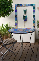 Ein Platz zum Sitzen: Terrasse im mediterranen Stil mit Mosaiktisch, Stuhl und Wasserspiel