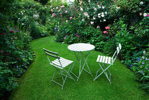 Garten mit Rasen, Holztisch und Stühlen