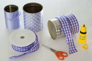 Tin cans jazzed up with purple ribbon (2/3)