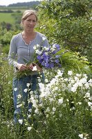 Woman cutting bluebells and grasses for a flowers bouquet