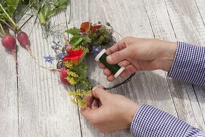 Small wreath of edible flowers, herbs and radishes