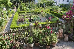 Künstlergarten : Gartenzaun mit Fuchsien und getöpferten Kunstobjekten
