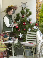 Woman decorates Pinus (pine) for Christmas