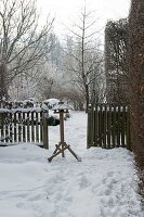 Blick auf Vogelfutterhaus im verschneiten Garten