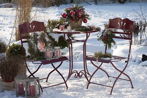 Verschneite Terrasse weihnachtlich geschmückt mit Strauß aus Ilex