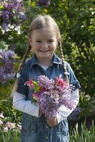 Girl with bouquet of Aquilegia (columbine) and Syringa (lilac)