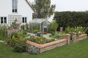 Small cottage garden with wall and greenhouse
