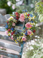 Colourful summer wreath of pinks (roses), raspberries (rubus), borage