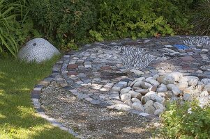 Interesting paved small terrace between beds