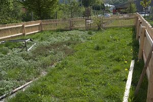 Noch nicht angelegter, unkultivierter Garten mit neuem Hanichelzaun