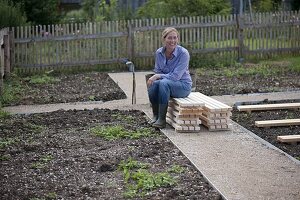 Woman sitting on pile of wooden grates