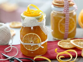 Homemade orange marmalade as a gift with lace ribbon