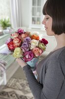 Woman enjoying a beautiful bouquet of pinks (roses)